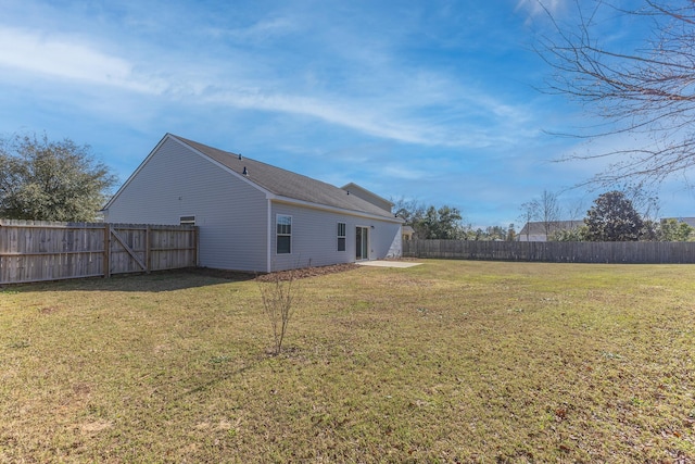 back of property with a fenced backyard, a patio, and a yard