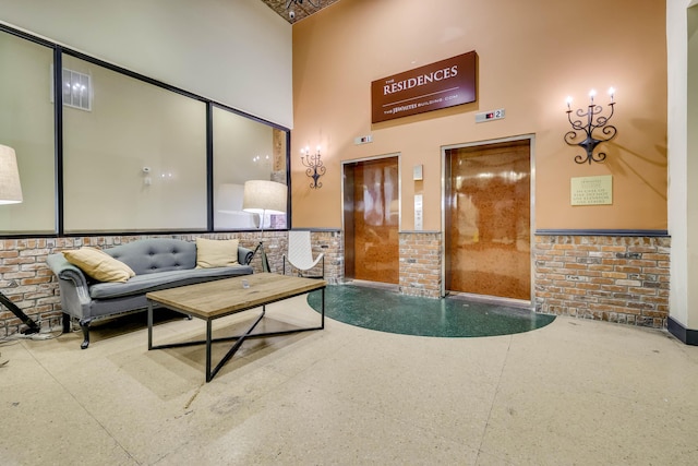 936 Broad St, Augusta, GA 30901 - living area with a towering ceiling, elevator, and brick wall