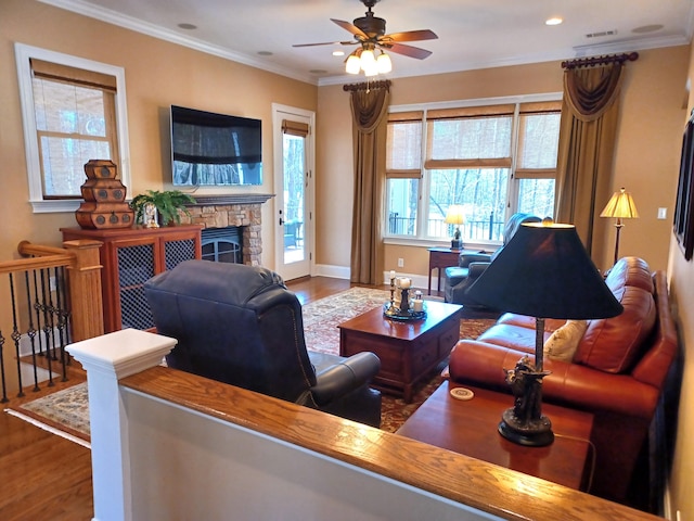 living area with wood finished floors, a ceiling fan, and ornamental molding