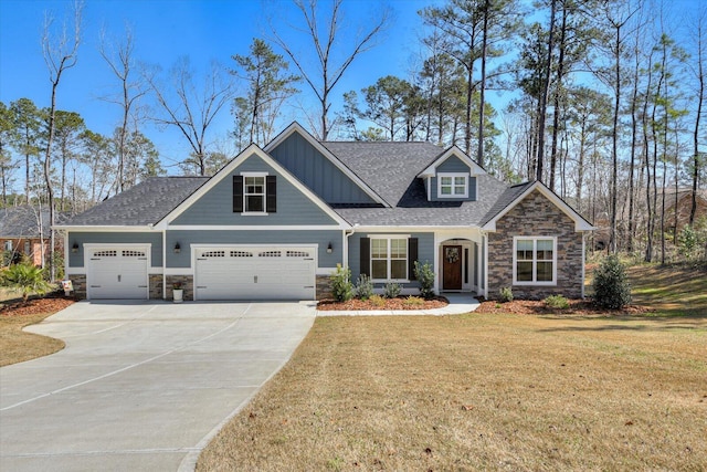 craftsman-style house featuring a front yard, an attached garage, stone siding, and driveway