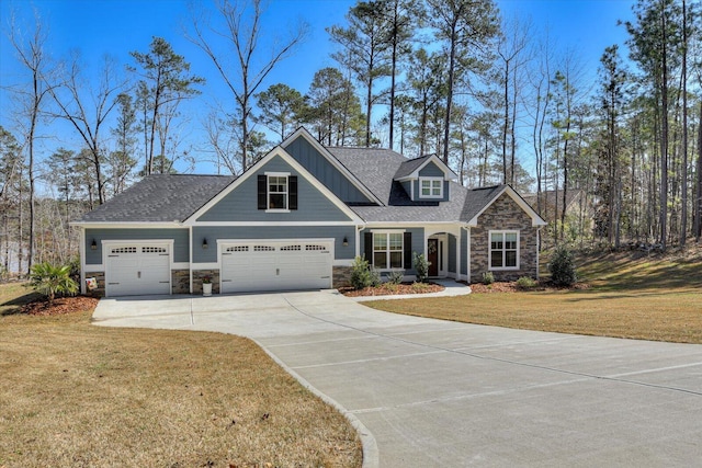 craftsman house with stone siding, an attached garage, concrete driveway, and a front lawn