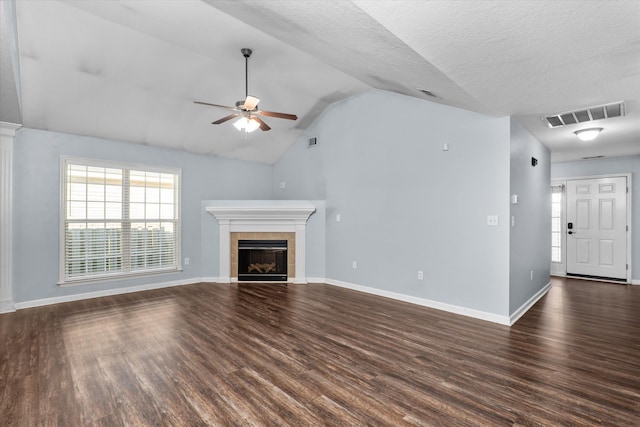 570 Lory Ln, Grovetown, GA 30813 - unfurnished living room featuring ceiling fan, a tiled fireplace, dark wood finished floors, vaulted ceiling, and a textured ceiling