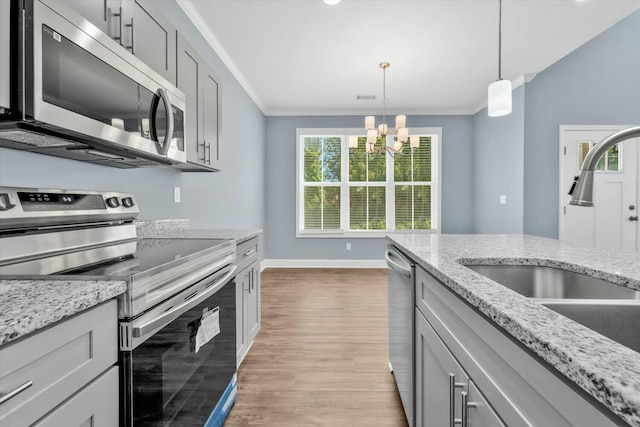 30 Gregg St, Augusta, GA 30901 - kitchen featuring a sink, baseboards, an inviting chandelier, crown molding, and appliances with stainless steel finishes