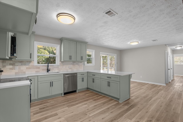 kitchen featuring dishwasher, tasteful backsplash, kitchen peninsula, and sink