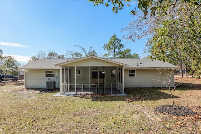 rear view of property featuring central AC unit, a lawn, and a sunroom