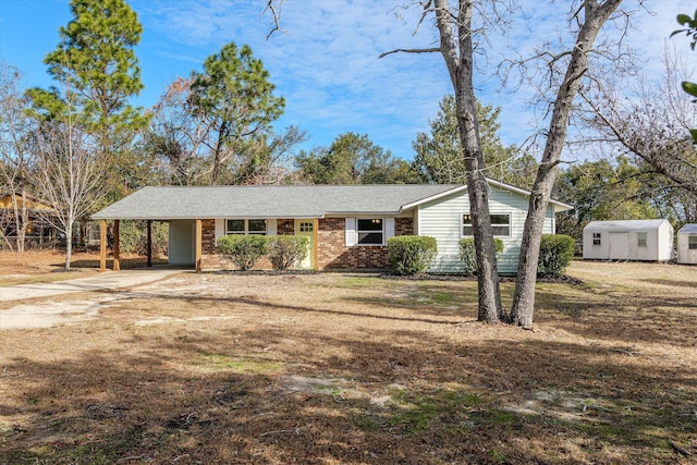 view of front of property featuring a storage unit and a carport