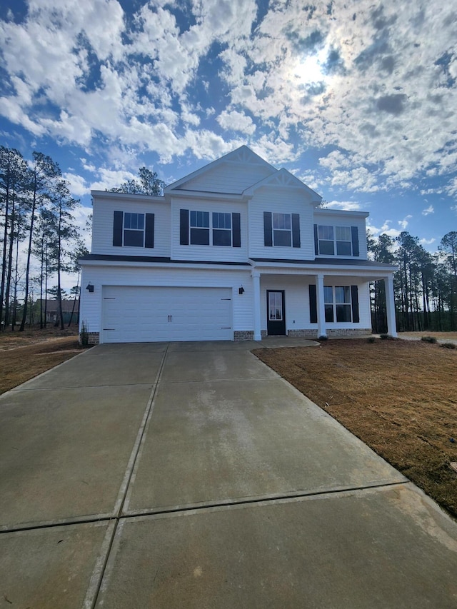 view of front of home featuring concrete driveway, a porch, and an attached garage