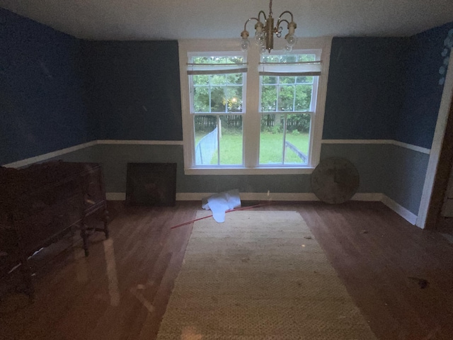 unfurnished dining area featuring a notable chandelier and wood-type flooring