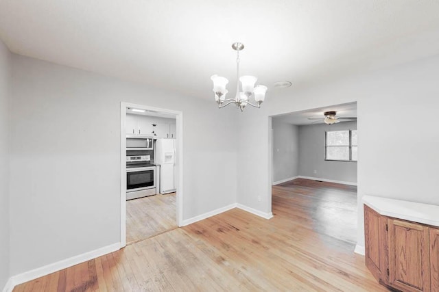 unfurnished dining area with ceiling fan with notable chandelier and light wood-type flooring