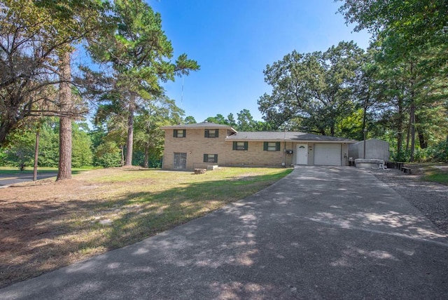 split level home featuring a garage and a front lawn