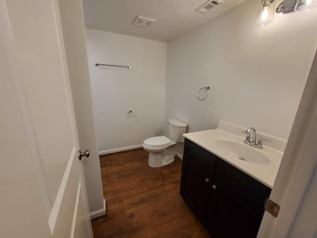 bathroom with hardwood / wood-style floors, vanity, and toilet