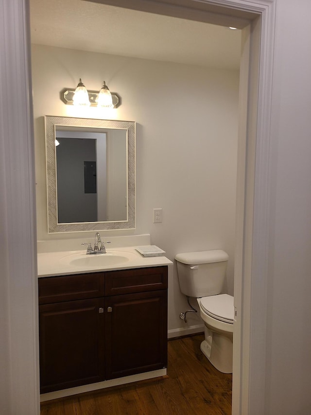 bathroom with hardwood / wood-style floors, vanity, and toilet