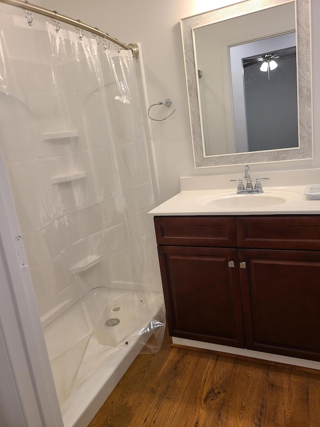 bathroom featuring hardwood / wood-style flooring, vanity, and walk in shower