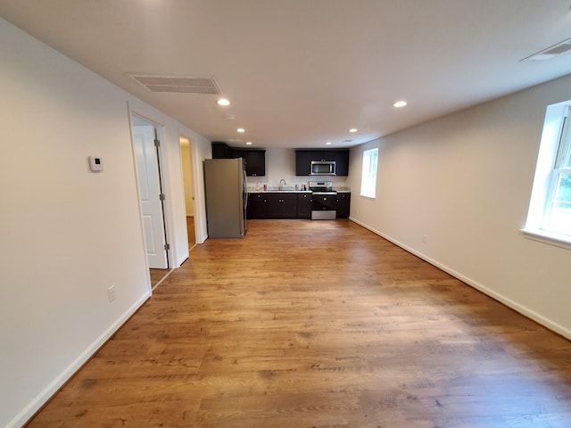 kitchen featuring stainless steel appliances, light hardwood / wood-style floors, and sink