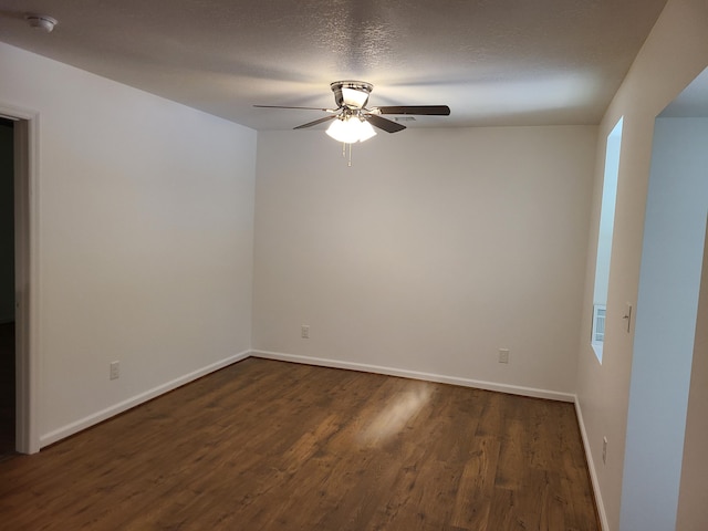 unfurnished room featuring ceiling fan, dark wood-type flooring, and a textured ceiling