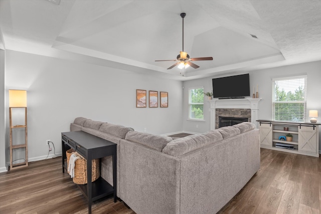 4894 Fairmont Dr, Graniteville, SC 29829 - living area with a raised ceiling, dark wood-style floors, a fireplace, a ceiling fan, and healthy amount of natural light