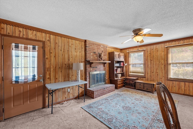 464 Rachel Dr, Evans, GA 30809 - living area featuring light carpet, wood walls, ceiling fan, a brick fireplace, and a textured ceiling