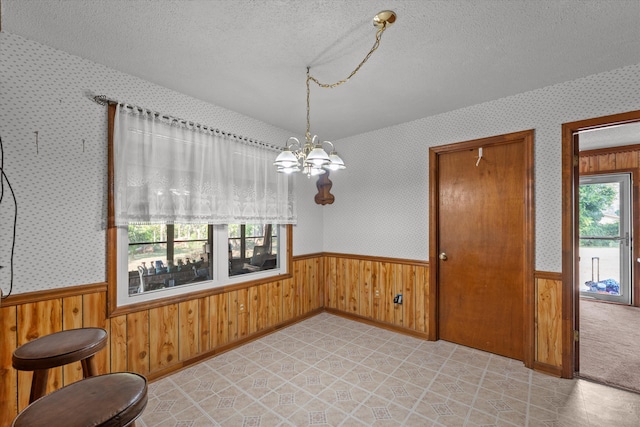464 Rachel Dr, Evans, GA 30809 - unfurnished dining area with wainscoting, a textured ceiling, a chandelier, and wood walls