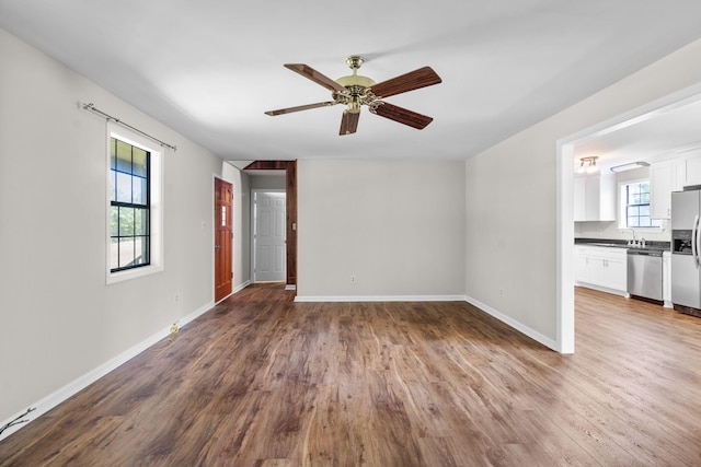 empty room with ceiling fan, hardwood / wood-style floors, and sink