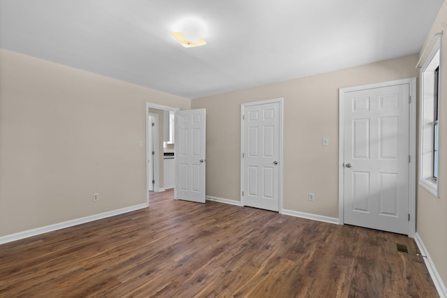 unfurnished bedroom with dark wood-type flooring