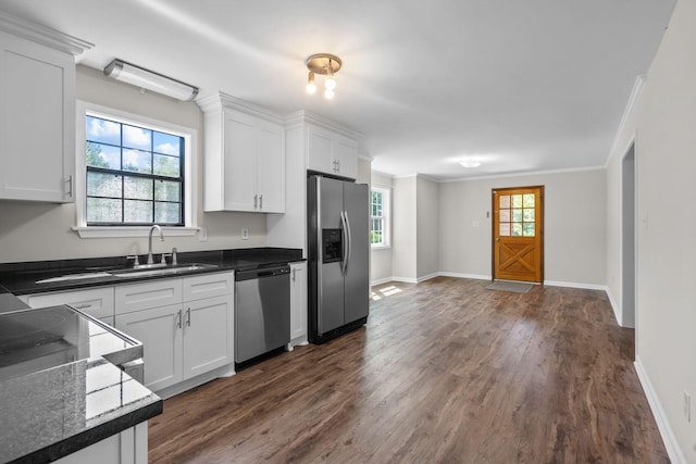 kitchen featuring appliances with stainless steel finishes, white cabinetry, ornamental molding, and sink