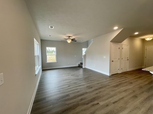 unfurnished living room featuring ceiling fan and dark hardwood / wood-style flooring