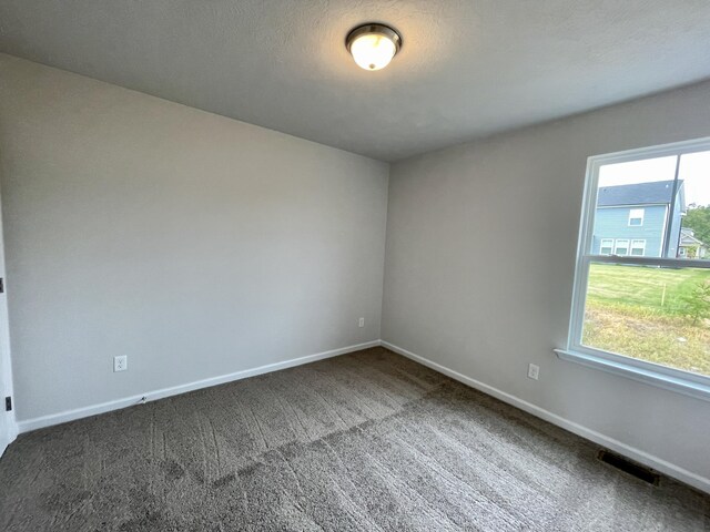 empty room featuring dark carpet