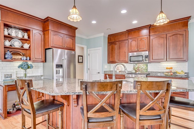 kitchen featuring a breakfast bar area, light stone counters, and stainless steel appliances