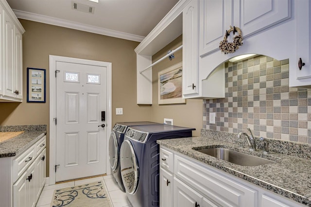 washroom with sink, cabinets, independent washer and dryer, light tile patterned floors, and ornamental molding