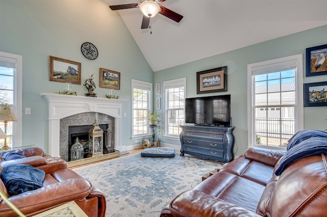 living room featuring plenty of natural light, high vaulted ceiling, and a tiled fireplace