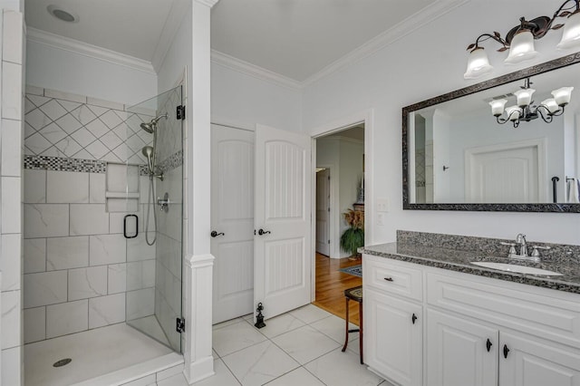 bathroom featuring crown molding, a shower with door, vanity, and a notable chandelier