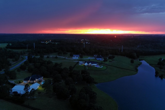 aerial view at dusk featuring a water view