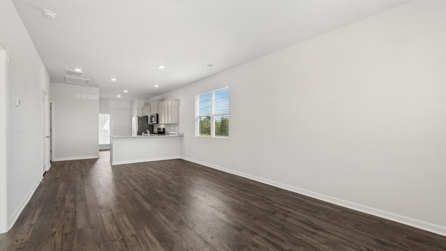 unfurnished living room with dark wood-style floors, baseboards, and recessed lighting