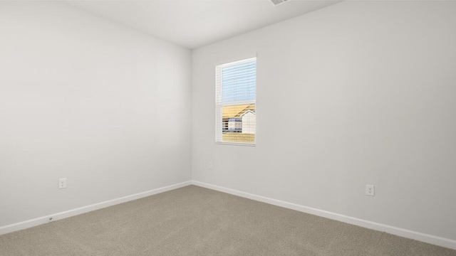 empty room featuring carpet floors and baseboards