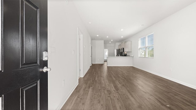 unfurnished living room with dark wood-style flooring, baseboards, and recessed lighting
