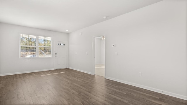 spare room with dark wood-type flooring, baseboards, and recessed lighting