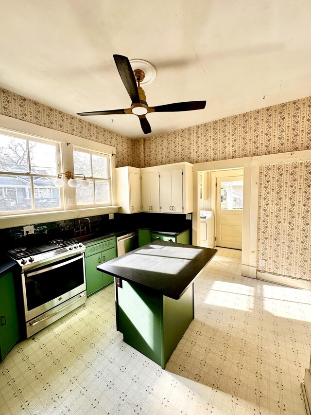 kitchen featuring ceiling fan, washer / clothes dryer, appliances with stainless steel finishes, white cabinets, and green cabinetry