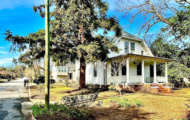 view of front of house featuring covered porch and a front yard