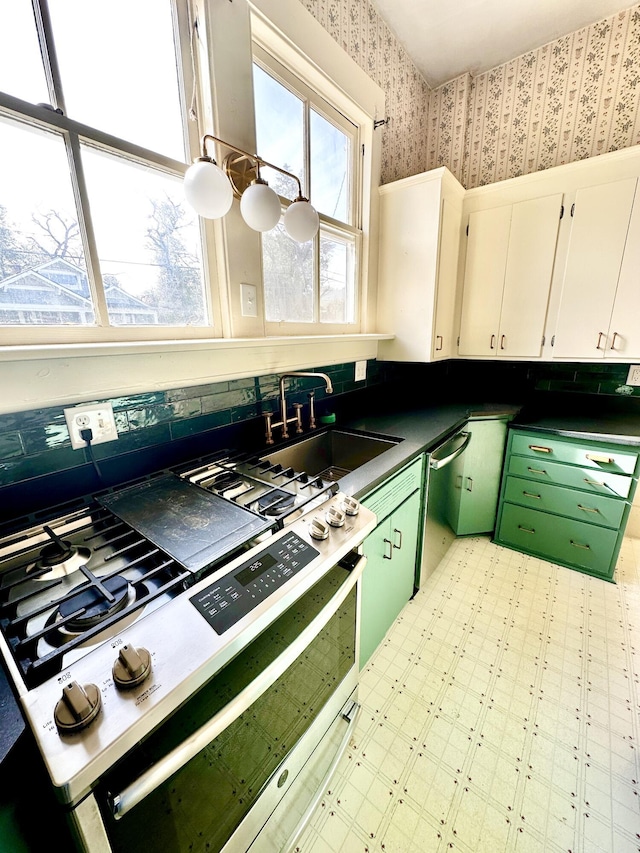 kitchen featuring gas stove, white cabinetry, sink, and dishwasher