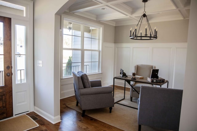 foyer with dark wood-type flooring, a chandelier, beamed ceiling, arched walkways, and coffered ceiling