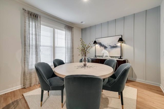 dining room with baseboards and light wood-type flooring