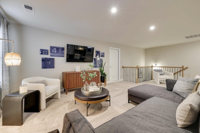 living area with visible vents, recessed lighting, baseboards, and light carpet