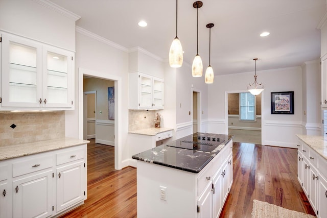 615 Stevens Xing, Augusta, GA 30907 - kitchen featuring black electric cooktop, hardwood / wood-style floors, a center island, light stone counters, and crown molding