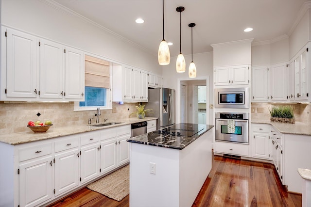 615 Stevens Xing, Augusta, GA 30907 - kitchen featuring appliances with stainless steel finishes, a center island, wood finished floors, light stone counters, and ornamental molding