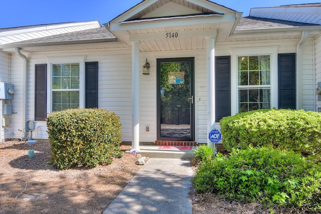 doorway to property featuring a shingled roof