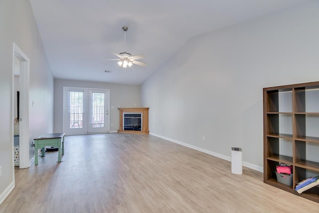 unfurnished living room featuring wood finished floors, baseboards, a ceiling fan, and vaulted ceiling