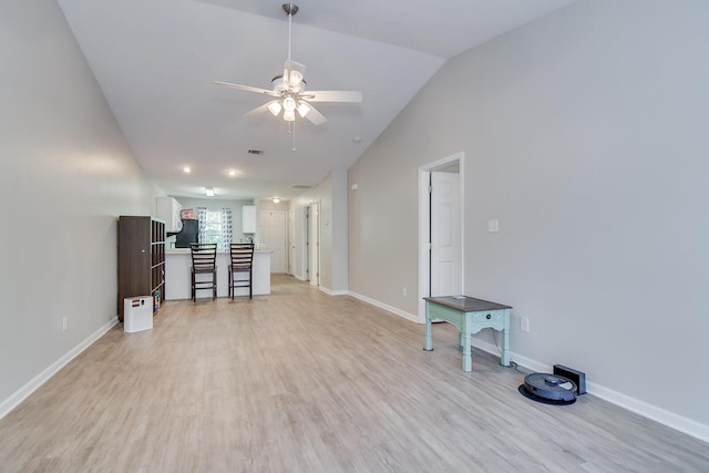 unfurnished living room with visible vents, baseboards, ceiling fan, light wood-style floors, and lofted ceiling