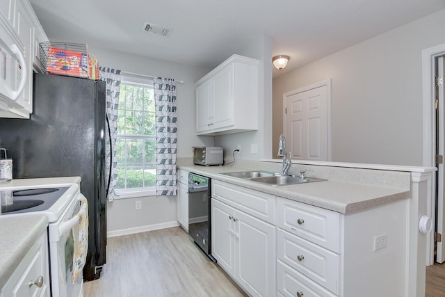 kitchen featuring light wood-type flooring, plenty of natural light, white appliances, visible vents, and a sink