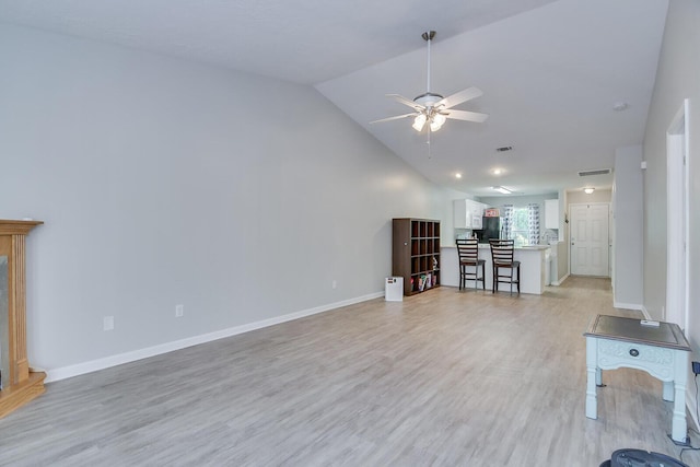 unfurnished living room with visible vents, baseboards, a ceiling fan, light wood finished floors, and high vaulted ceiling