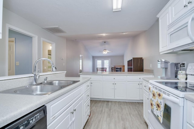 kitchen featuring white appliances, visible vents, light countertops, and a sink